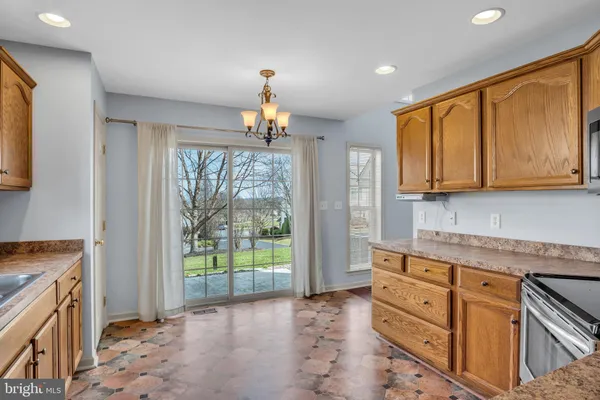 a kitchen with granite countertop wooden cabinets a stove and a window