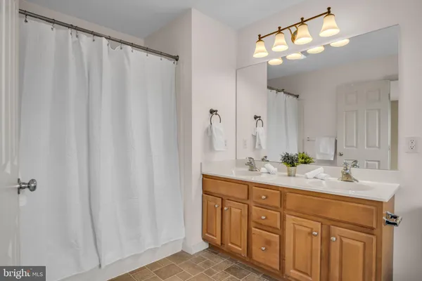 a spacious bathroom with a double vanity sink and mirror