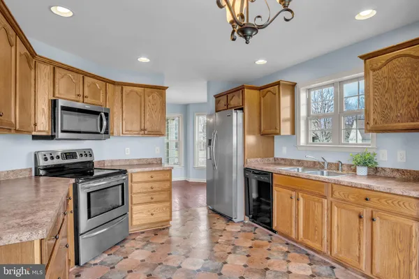 a kitchen with stainless steel appliances granite countertop a refrigerator a stove top oven a sink and dishwasher