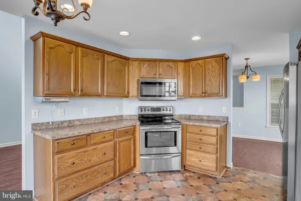 a kitchen with stainless steel appliances granite countertop a stove microwave and cabinets