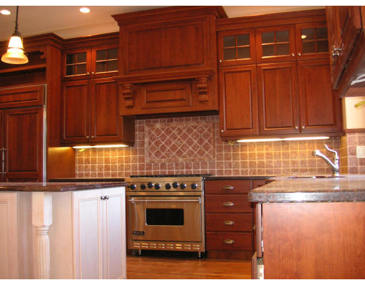 82 Herrick Road Newton, MA 02459 - Photo 9 of 12 a kitchen with granite countertop wooden cabinets and white appliances