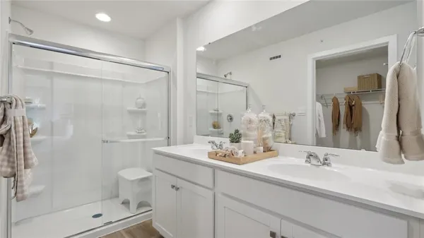 a bathroom with a shower sink vanity and mirror