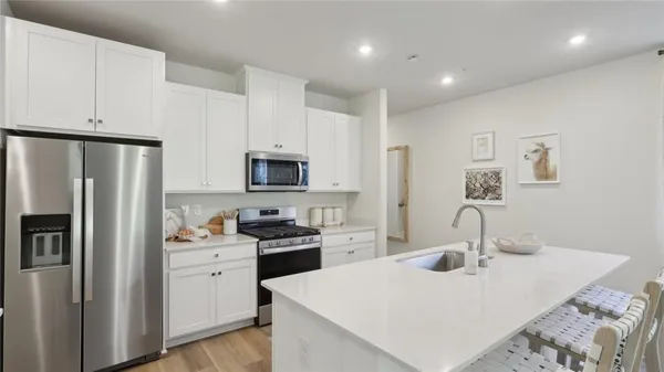 a kitchen with stainless steel appliances a refrigerator stove microwave and sink