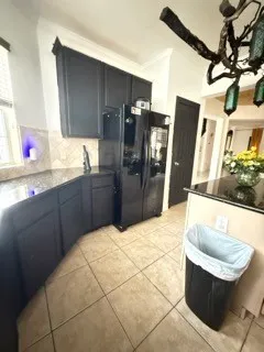 a kitchen with stainless steel appliances kitchen island granite countertop a refrigerator and a sink