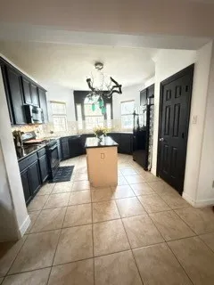 a kitchen with granite countertop a refrigerator and a stove top oven