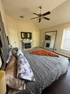 a bedroom with a bed a fireplace and a flat tv screen