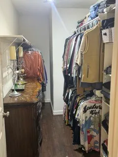 a view of walk in closet with clothes and shoes