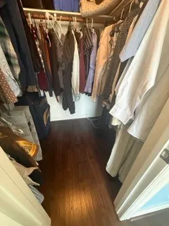 a view of walk in closet with clothes and shoes
