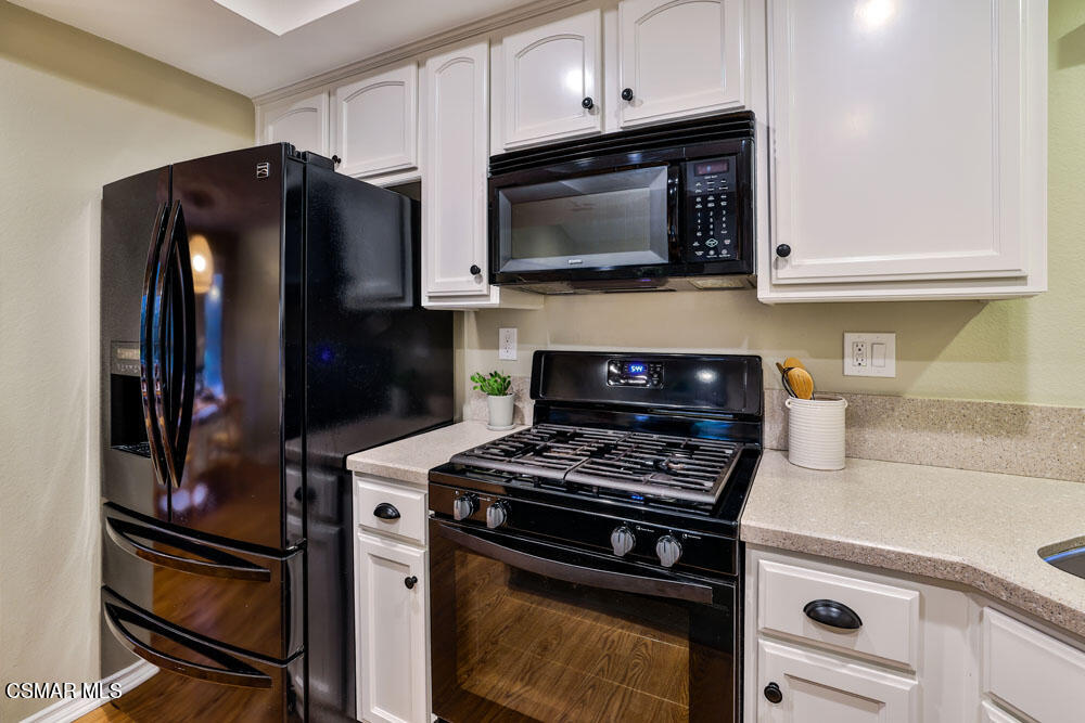 13777 Gunsmoke Road Moorpark, CA 93021 - Photo 15 of 42 a kitchen with stainless steel appliances a stove a microwave and cabinets