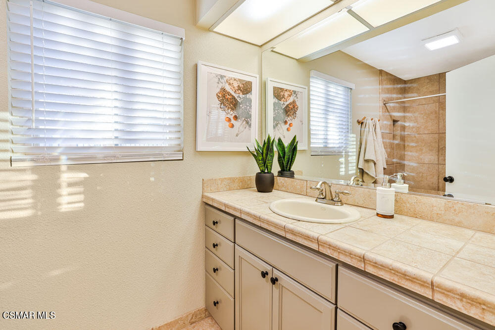 13777 Gunsmoke Road Moorpark, CA 93021 - Photo 25 of 42 a bathroom with a granite countertop sink mirror and a window