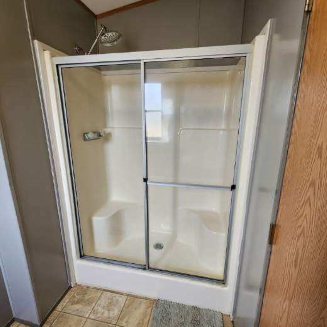 3595 Gainsville Road Mason, TN 38049 - Photo 18 of 28 a bathroom with a glass shower door