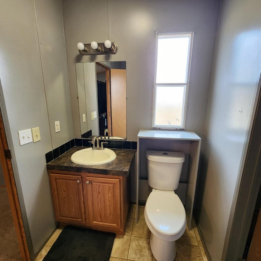3595 Gainsville Road Mason, TN 38049 - Photo 26 of 28 a bathroom with a toilet sink and mirror