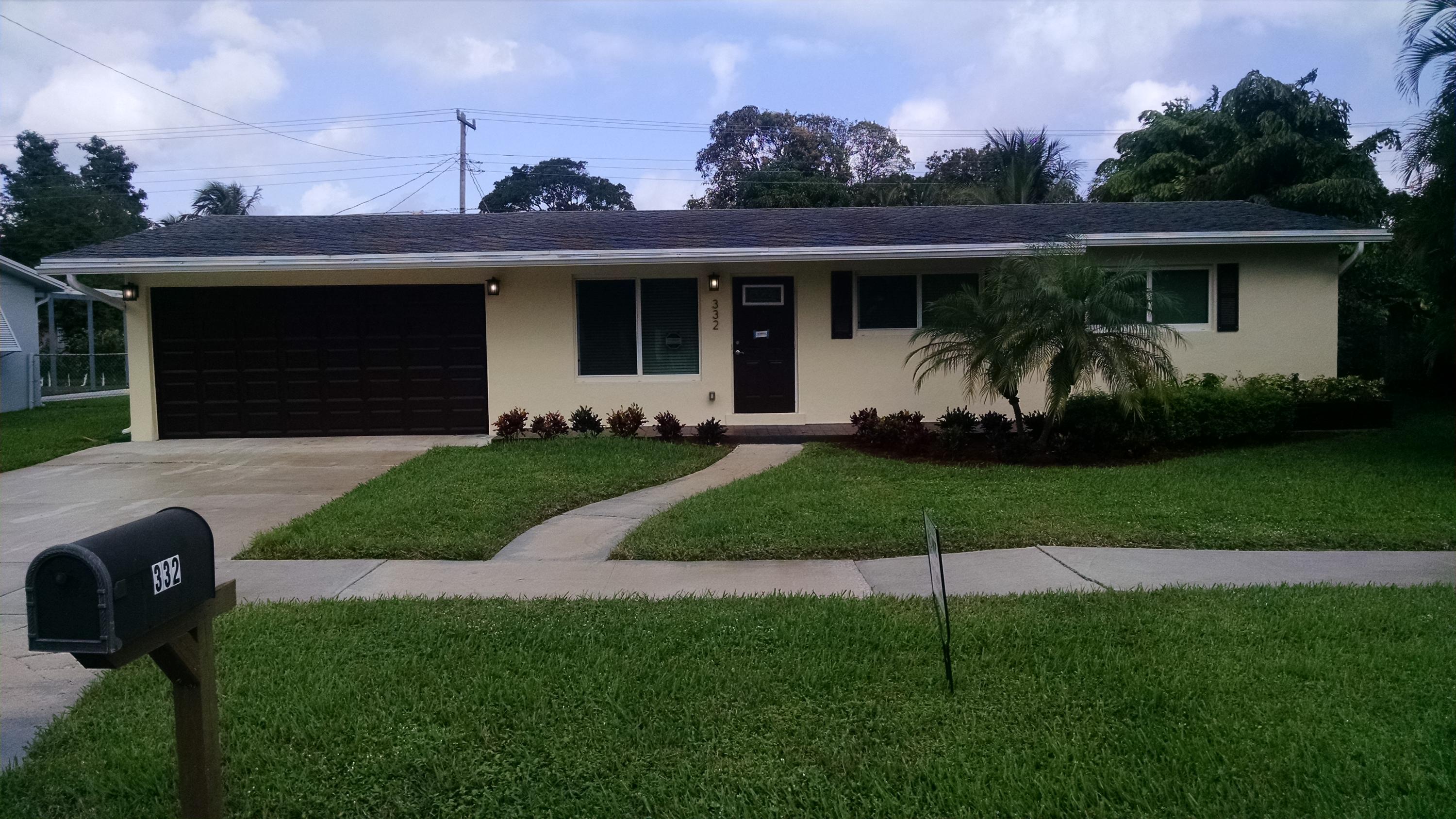 332 Cavalier Road Palm Springs, FL 33461 - Photo 1 of 16 a front view of a house with a garden and yard