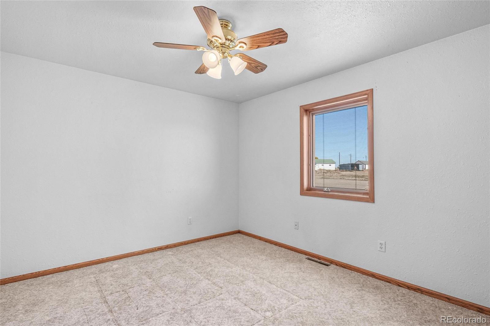 55 Cook Court Hudson, CO 80642 - Photo 21 of 50 an empty room with a window and a ceiling fan