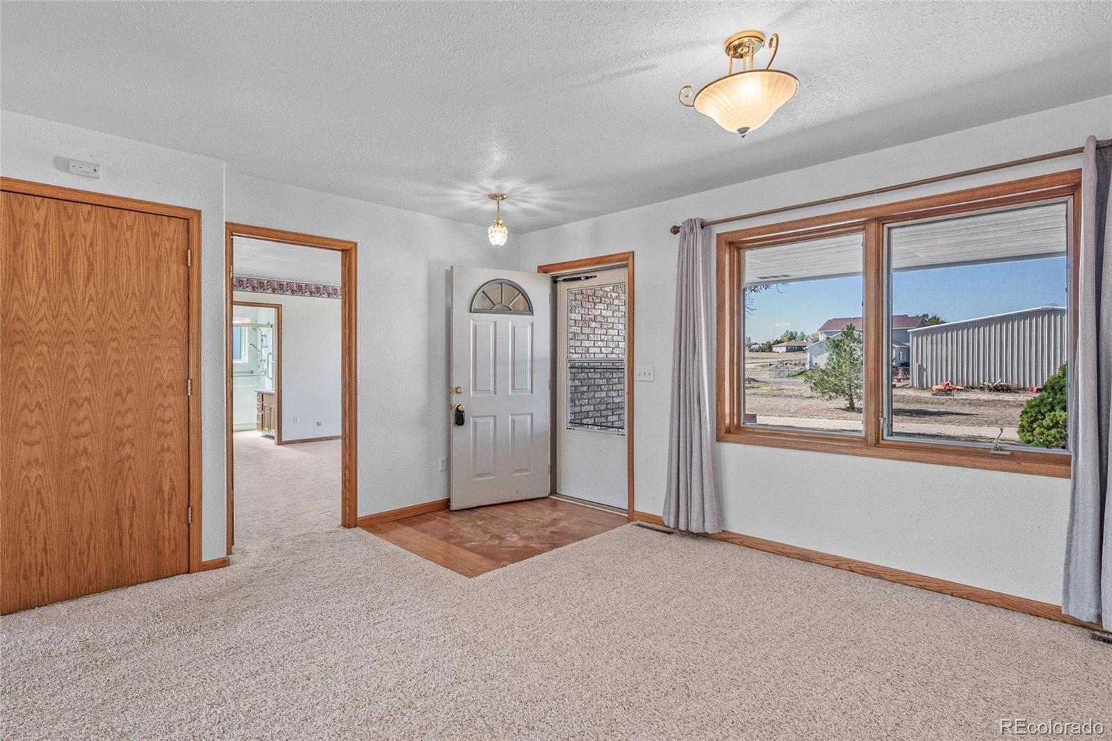 55 Cook Court Hudson, CO 80642 - Photo 3 of 50 an empty room with windows and garden