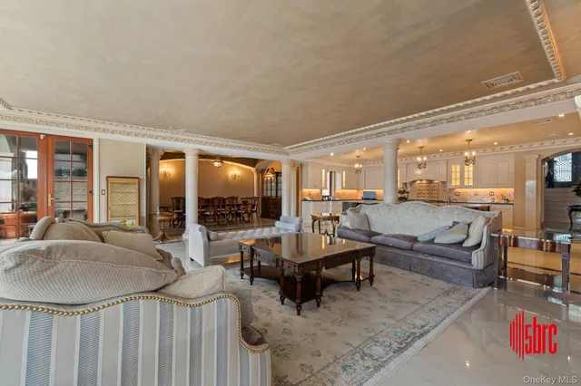 a spacious bedroom with a bed a chandelier and flat screen tv