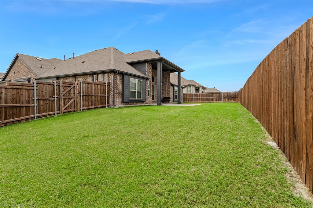 2139 Devonblue Drive Forney, TX 75126 - Photo 27 of 30 View of Back yard with extended patio cover, ceiling fan, and a 10 x 20 concrete pad addition. Wood fence.