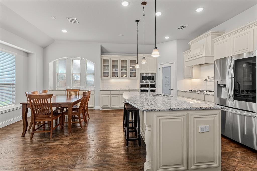 2139 Devonblue Drive Forney, TX 75126 - Photo 6 of 30 Deluxe Kitchen with Pot and Pan Drawers, Level 3 Granite Upgrade, Pendant lights over large island, under cabinet lighting, 36" Five Burner Gas Cooktop, Pot Filler above Range, Stainless Steel Convection Oven and Microwave, tons of cabinet space and breakfast area.