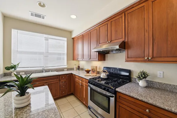 a kitchen with stainless steel appliances granite countertop a sink a stove and cabinets