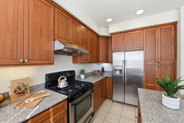 a kitchen with stainless steel appliances granite countertop a stove a refrigerator a sink and dishwasher