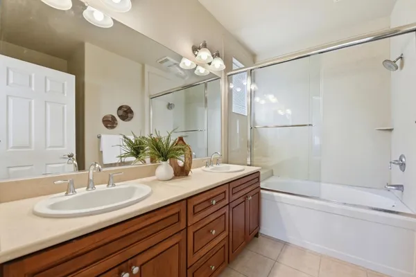 a bathroom with a granite countertop sink a large mirror and a bathtub