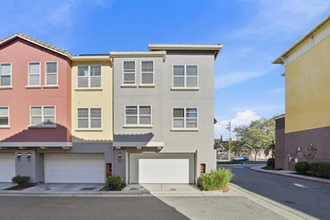 a front view of a house with a yard and parking