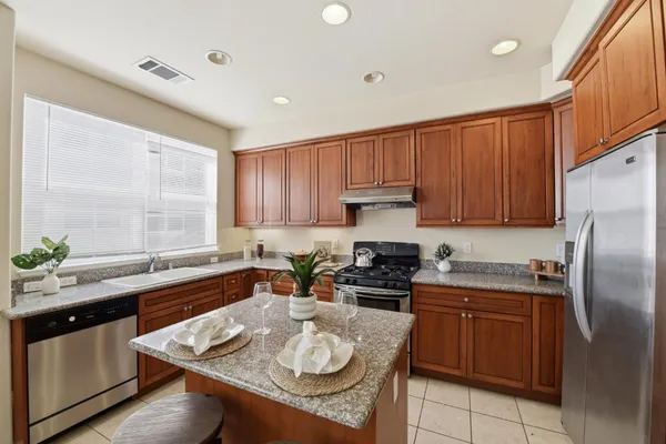 a kitchen with stainless steel appliances granite countertop a sink stove and refrigerator