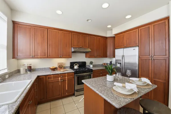 a kitchen with a sink a stove and chairs