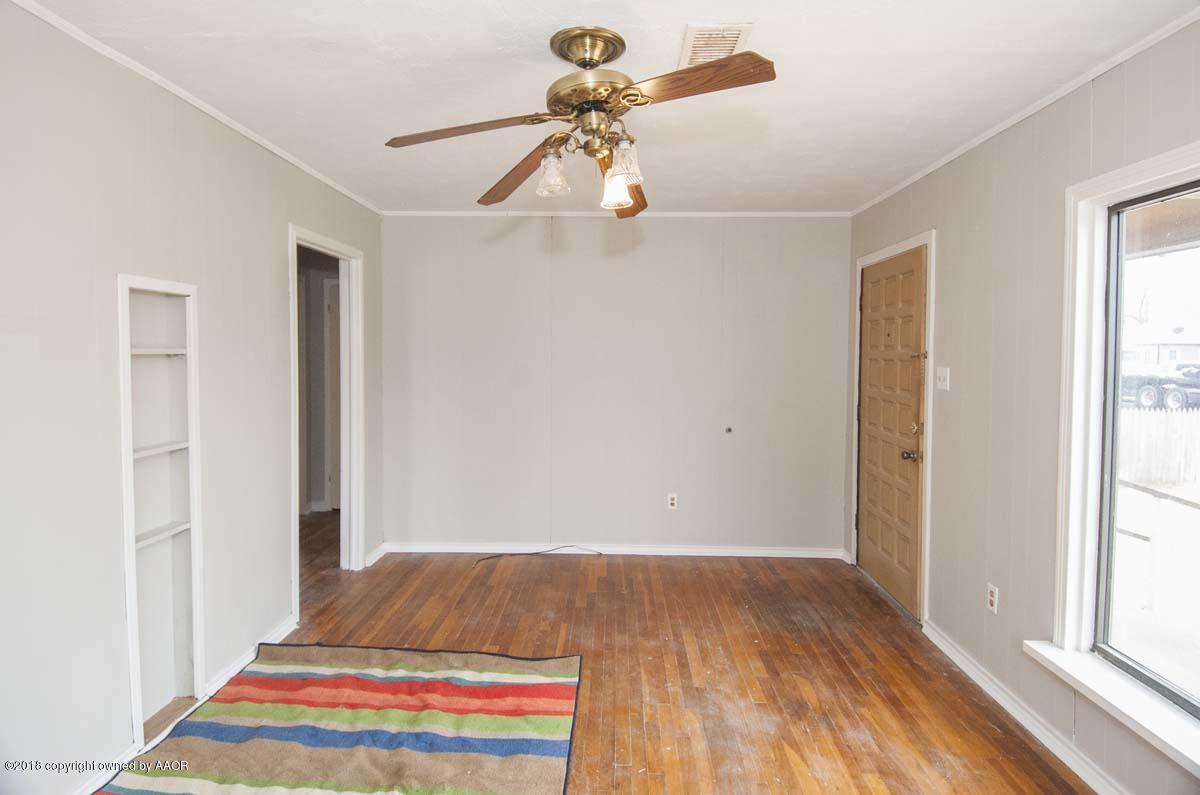4211 South Harrison Street Amarillo, TX 79110 - Photo 11 of 22 a bedroom with a bed and a chandelier