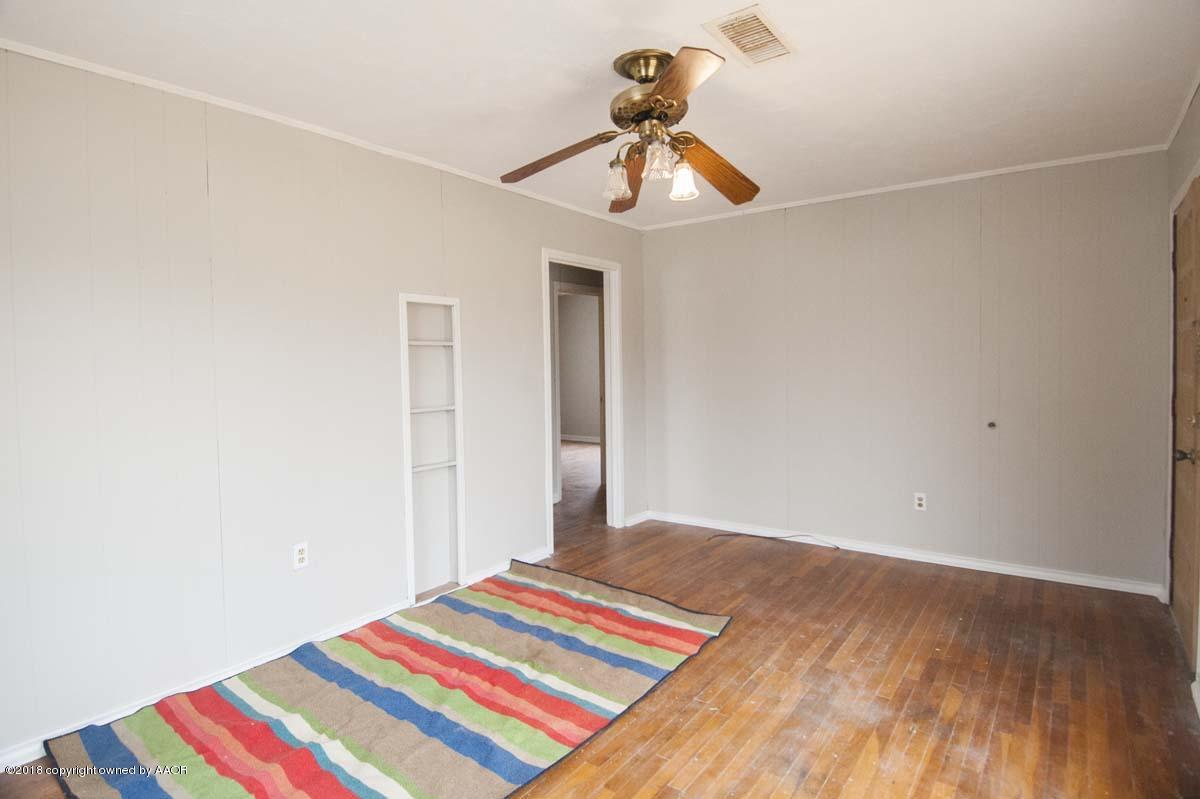 4211 South Harrison Street Amarillo, TX 79110 - Photo 14 of 22 a room with a bed and a chandelier