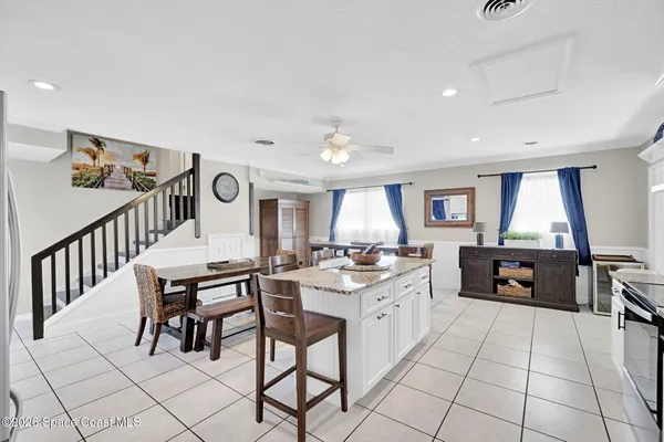 a kitchen with stainless steel appliances kitchen island granite countertop a table and chairs in it