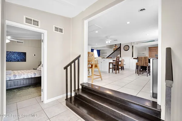 a kitchen with stainless steel appliances kitchen island granite countertop a refrigerator a stove top oven and a dining table with wooden floor