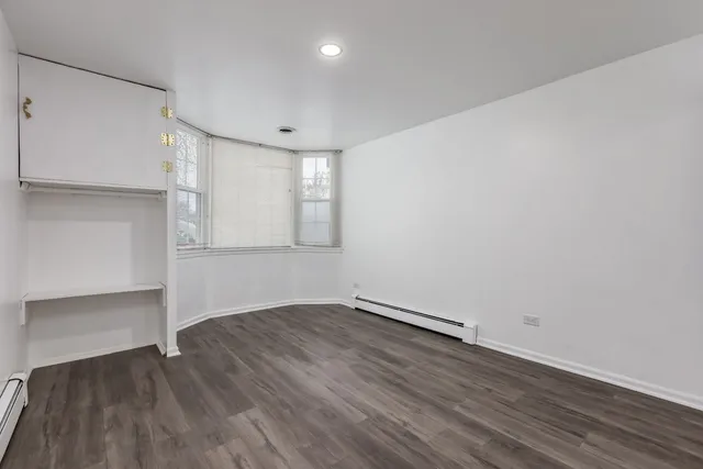 an empty room with wooden floor and closet