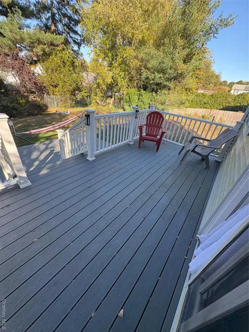 a view of deck and ocean with trees in the background