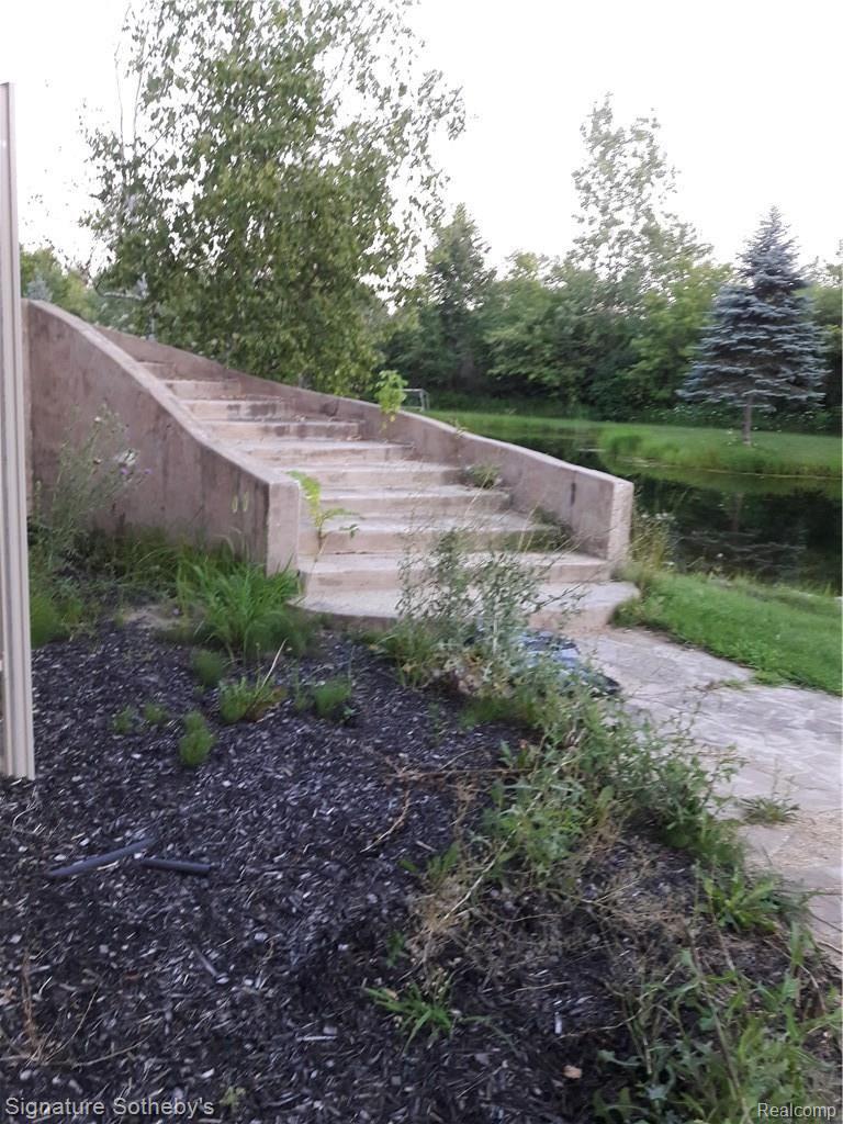 5000 Lake Pleasant Road North Branch, MI 48461 - Photo 13 of 34 Steps from pool area to the walk out basement doors and the pond.