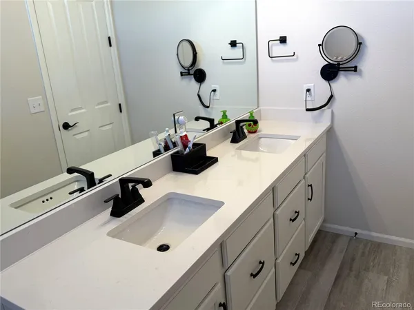 a bathroom with double vanity sink and mirror