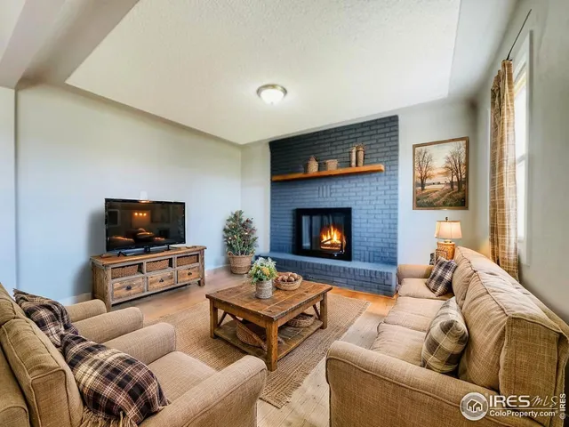 a living room with furniture a flat screen tv and a fireplace