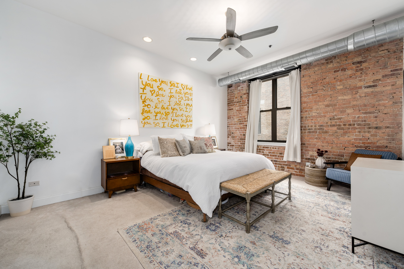 23 North Green Street, Unit 402 Chicago, IL 60607 - Photo 14 of 18 a spacious bedroom with a bed a couch and a potted plant