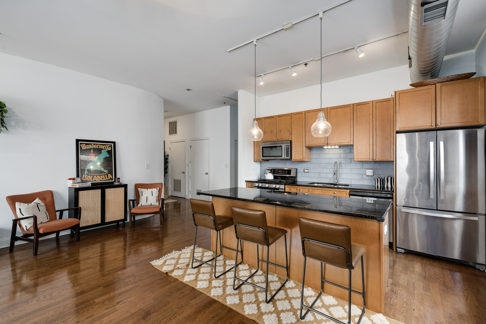 23 North Green Street, Unit 402 Chicago, IL 60607 - Photo 10 of 18 a kitchen with granite countertop a table chairs microwave and cabinets