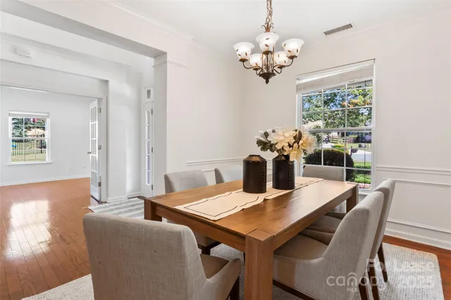 a view of a dining room with furniture a chandelier and wooden floor
