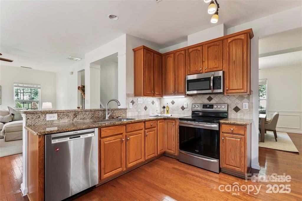 2003 Red Carpet Court Indian Trail, NC 28079 - Photo 25 of 28 a kitchen with stainless steel appliances granite countertop a stove top oven a sink dishwasher a refrigerator and a microwave