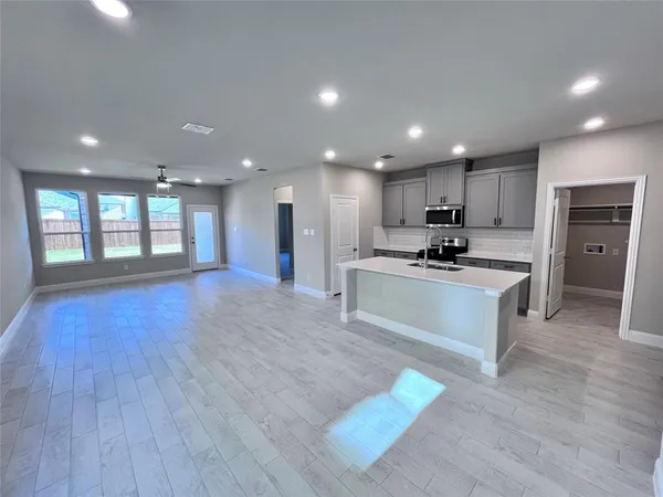 a large kitchen with stainless steel appliances granite countertop a large counter top a sink and a stove