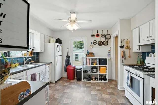 a kitchen with stainless steel appliances kitchen island granite countertop a refrigerator and a stove top oven