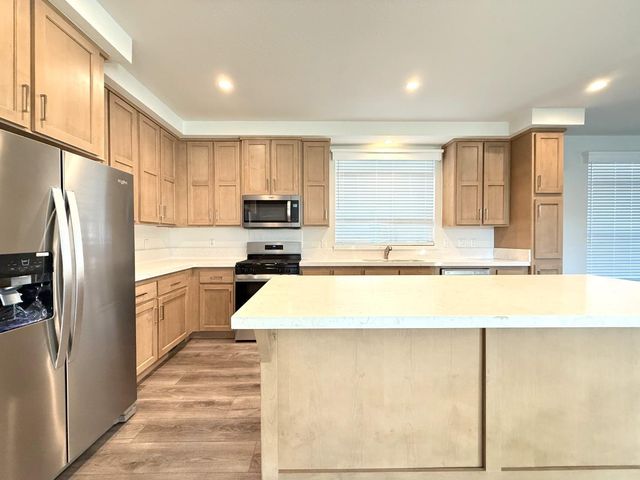 a view of a kitchen with a sink and wooden floor