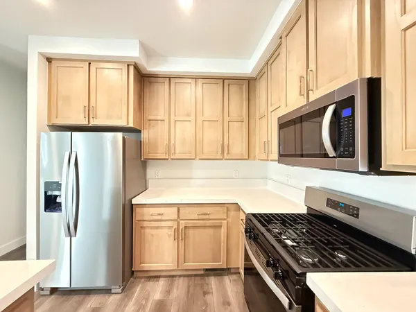 a kitchen with stainless steel appliances granite countertop a stove a refrigerator and a microwave