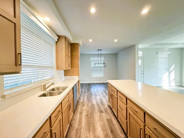 a view of a kitchen with a sink and wooden floor