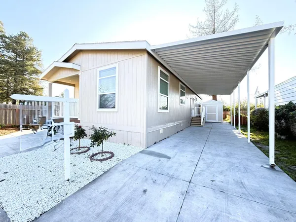 a view of a house with backyard and sitting area