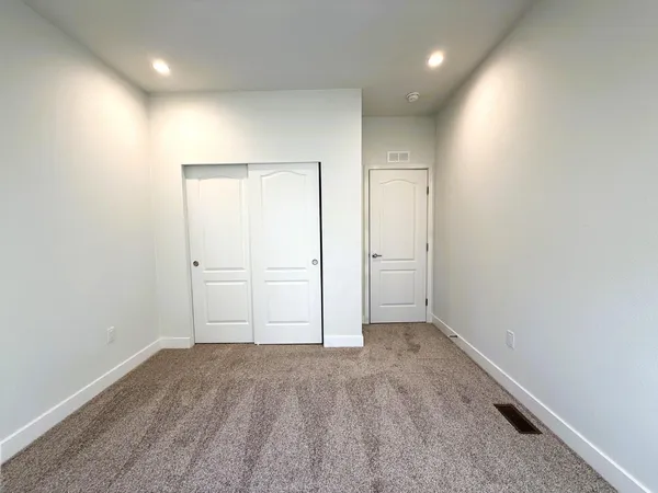 an empty room with closet and mirror