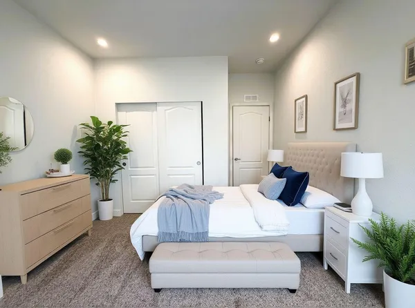 a bedroom with a bed and a potted plant