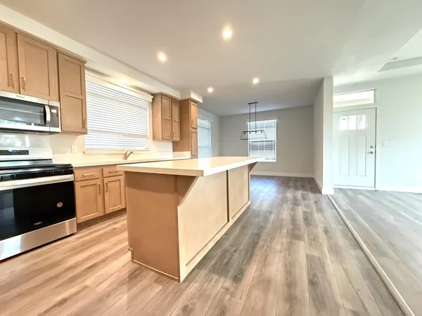 a large kitchen with stainless steel appliances granite countertop a sink and cabinets